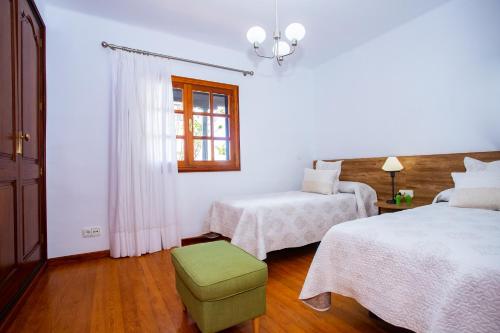 a white room with two beds and a window at Casa Seara Piscina, Wifi y 400 metro de la playa, in Arrecife