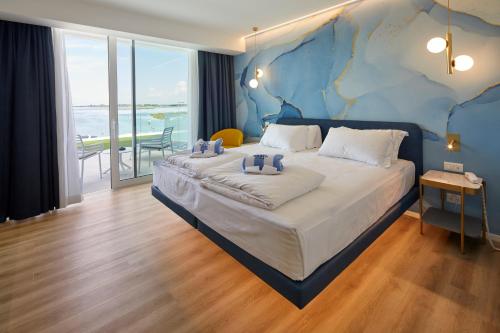 ein Schlafzimmer mit einem großen Bett mit einer Karte an der Wand in der Unterkunft Riva Palace Hotel in Grado