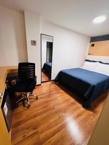 a bedroom with a bed and a desk and a chair at OQ STANDARD HOTEL - Airport in Arequipa
