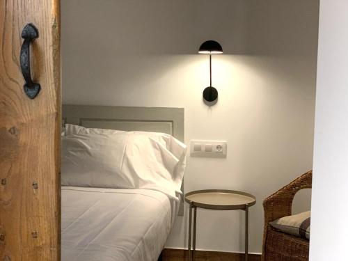 a bedroom with a bed and a table and a lamp at A Parada House by Kev in Parada del Sil