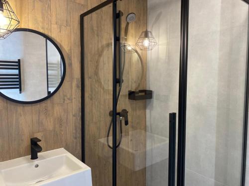 a bathroom with a shower and a sink and a mirror at Royal Blue Port in Rowy
