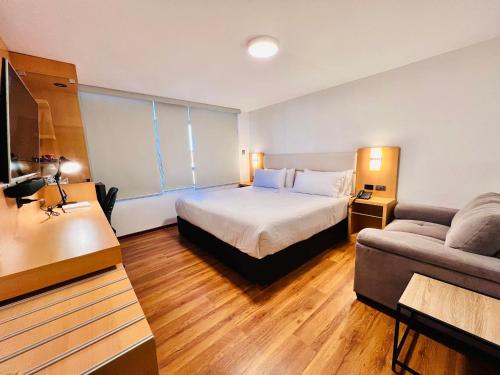 Habitación de hotel con cama y sofá en OQ STANDARD HOTEL - Airport, en Arequipa