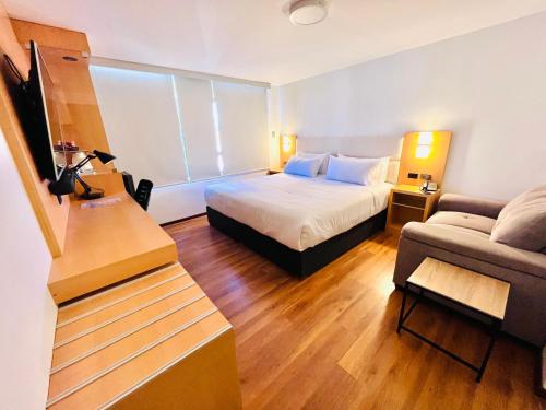 a hotel room with a bed and a couch at OQ STANDARD HOTEL - Airport in Arequipa
