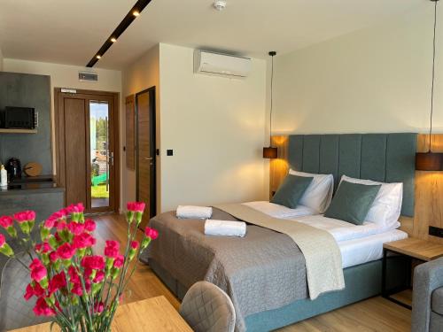 a bedroom with a bed and a vase of flowers at Royal Blue Port in Rowy