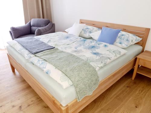a bed with blue and white sheets and pillows at Beim Lanner - Franz in Mondsee