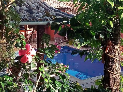 una piscina en el patio de una casa con un árbol en Pousada Mar a Mar, en Búzios