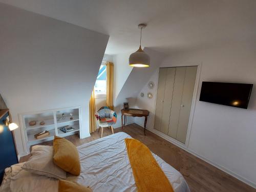 a bedroom with a bed and a tv on a wall at L'escale d'Armor in Loudéac