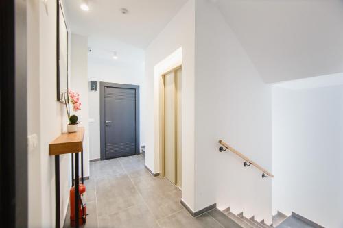 a hallway with a blue door and a staircase at Pink Sahara near City Center in Oradea