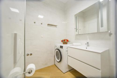 a white bathroom with a washing machine and a sink at Pink Sahara near City Center in Oradea