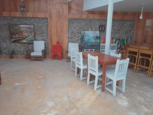a room with a table and chairs and a stone wall at Alojamientos Támpur in San Mateo