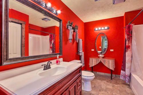 a red bathroom with a sink and a mirror at Dragon Castle with Secret Passage, Dock, and Hot Tub in Camdenton