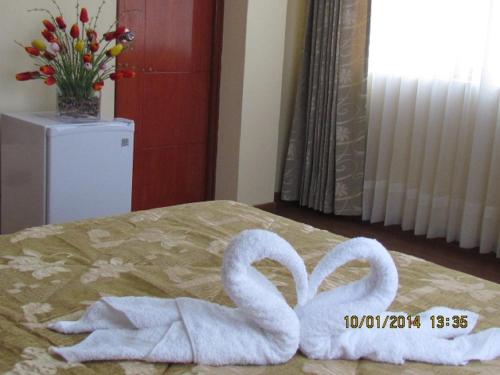 two towel swans sitting on top of a bed at Hotel Torresur Tacna in Tacna