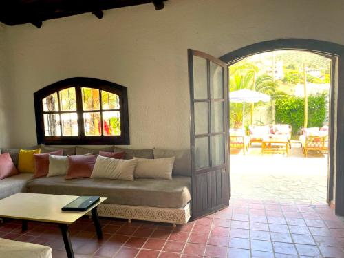 a living room with a couch and an open door at Dar Maria - Maison d'hôtes in Aouchtame
