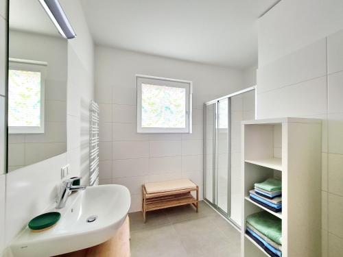 ein weißes Badezimmer mit Waschbecken und Spiegel in der Unterkunft Beim Lanner - Maria in Mondsee