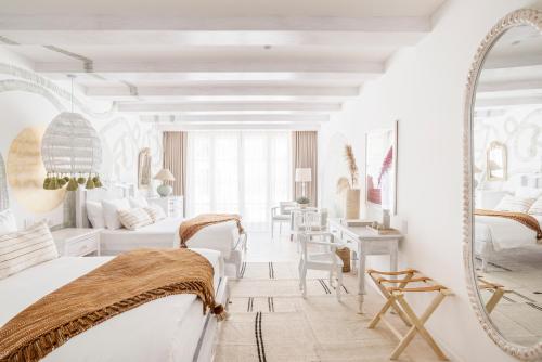 a white room with a bed and a mirror at Villa Bokeh Relais & Châteaux in Antigua Guatemala