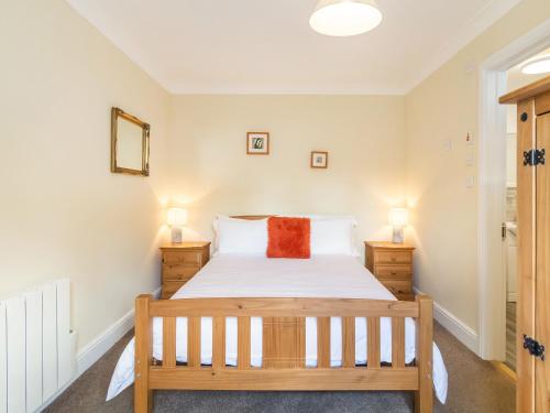 ein Schlafzimmer mit einem Bett und zwei Nachttischen in der Unterkunft Norbank Garden Studio in Bressingham
