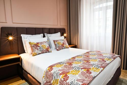 a bedroom with a large bed with a colorful comforter at 6/4 de Lamego in Lamego