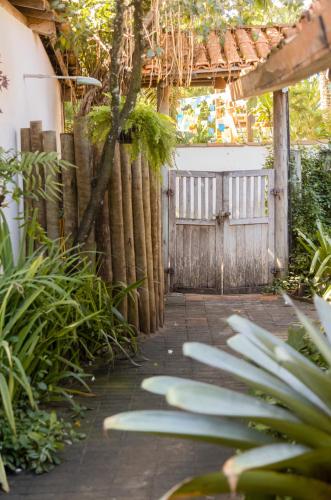 a garden with a gate and a fence at Pousada Solar Caraíava in Caraíva