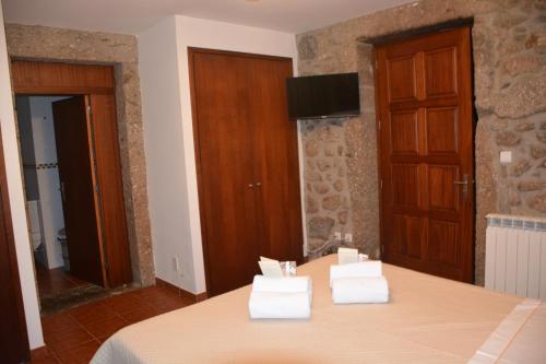 ein Zimmer mit einem Tisch und weißen Handtüchern darauf in der Unterkunft Quinta da Cachada in Moure