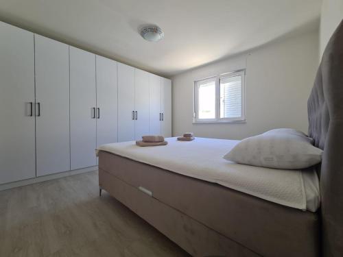 a bedroom with a large bed with white cabinets at Blue sky apartment by Pag tours in Pag