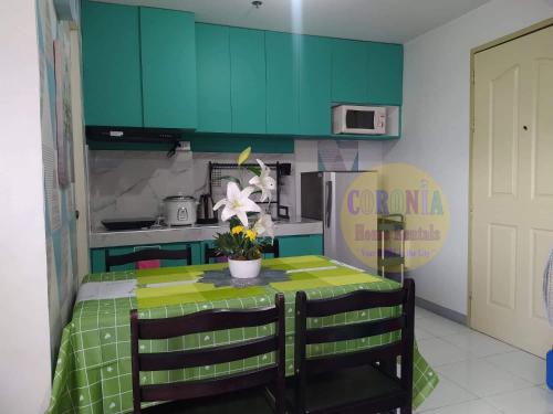 a kitchen with a table with a green kitchen at Isabelle De Valenzuela Condo Staycation in Marulas Valenzuela in Manila
