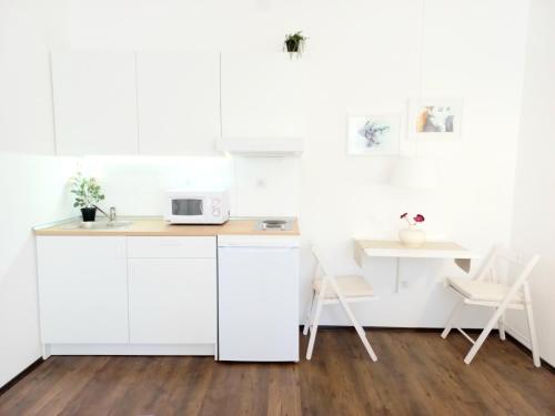 贝尔格莱德GENIUS STUDIO的白色的厨房配有微波炉和桌子