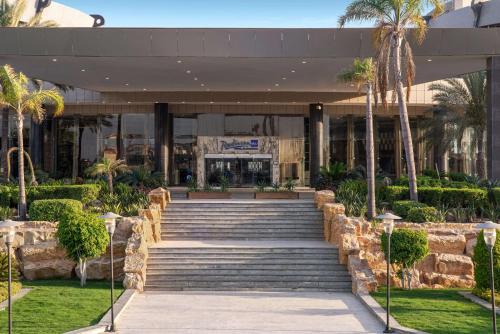 فندق راديسون بلو، الإسكندرية في الإسكندرية: مبنى امامه درج والنخيل
