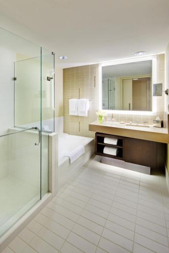 a bathroom with a shower and a sink and a mirror at Fairmont Pittsburgh in Pittsburgh