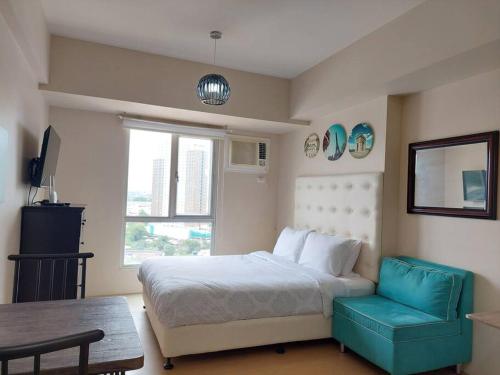 a bedroom with a bed and a chair and a window at Home in the Heart of Cagayan De Oro City in Cagayan de Oro