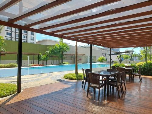 a wooden deck with a table and chairs and a pool at Home in the Heart of Cagayan De Oro City in Cagayan de Oro
