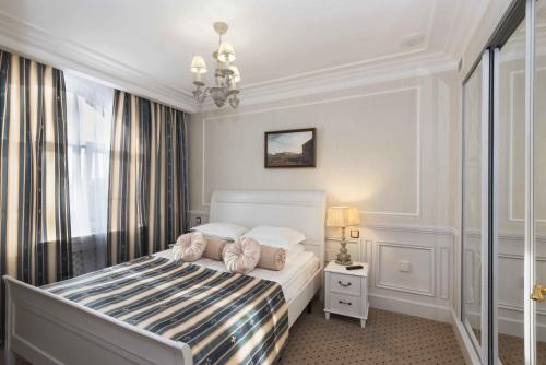 - une chambre blanche avec un lit et une fenêtre dans l'établissement Aglaya Hotel & Courtyard, à Saint-Pétersbourg