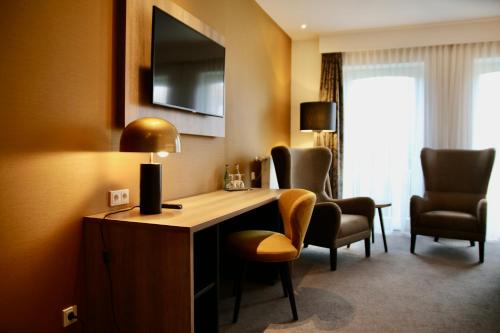 a hotel room with a desk and two chairs at Hotel Rheinischer Hof in Dinklage