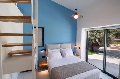 a bedroom with a bed and a staircase at RIZOMATA LUXURY VILLAS in Lefkada Town
