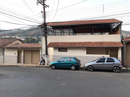 due auto parcheggiate di fronte a un edificio di Aconchegante Apartamento em Ouro Preto a Ouro Preto