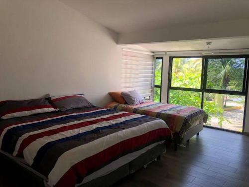 a bedroom with two beds and a large window at Casa c/embarcadero en Boca del Río Gran Ubicación in Boca del Río