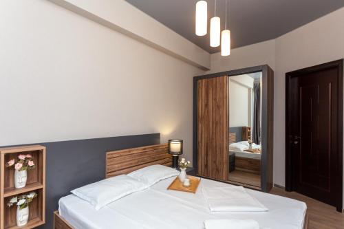 a bedroom with a bed and a mirror at Saburtalo Apartment in Tbilisi City