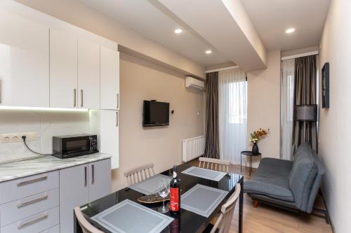 a kitchen and living room with a table in a room at Saburtalo Apartment in Tbilisi City
