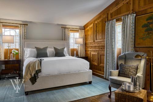 a bedroom with a bed and a chair at Wickwood Inn in Saugatuck
