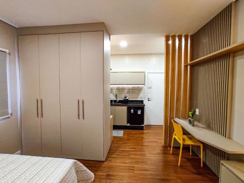 Il comprend une chambre avec un lit, un bureau et une cuisine. dans l'établissement Apartamentos Studio no centro de Foz do Iguaçu, à Foz do Iguaçu