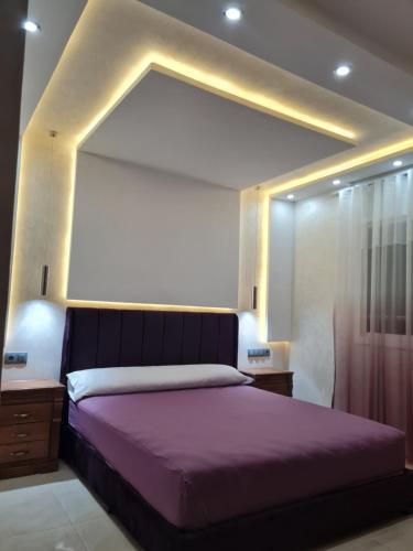 ナドールにあるAppartement a Nadorのベッドルーム(紫の毛布を使用した大型ベッド1台付)