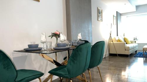 a table with green chairs in a living room at Sky-Rise Apartments in Los Angeles