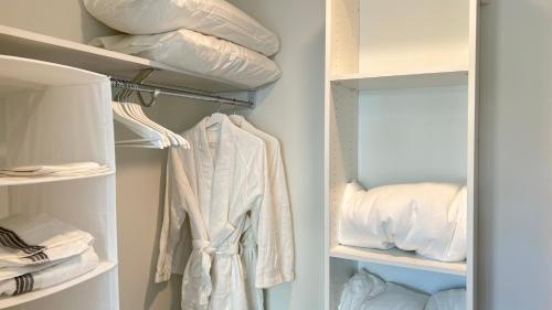 a closet with white shirts and pillows at Sky-Rise Apartments in Los Angeles