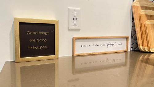two framed signs on a table next to a wall at Sky-Rise Apartments in Los Angeles