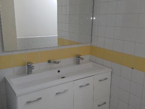 a bathroom with a white sink and a mirror at Gîte tout confort près du circuit des 24 Heures, cadre verdoyant, étang clos, 6 pers., lits faits - FR-1-410-207 in Moncé-en-Belin
