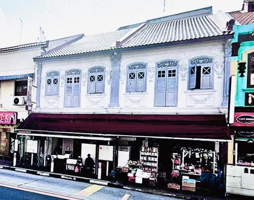 een wit gebouw met een winkel voor een straat bij Atlantis@531 in Singapore