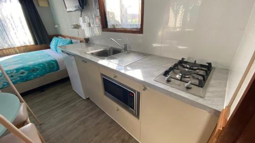 a small kitchen with a sink and a stove at Twin Dolphins Holiday Park in Tuncurry