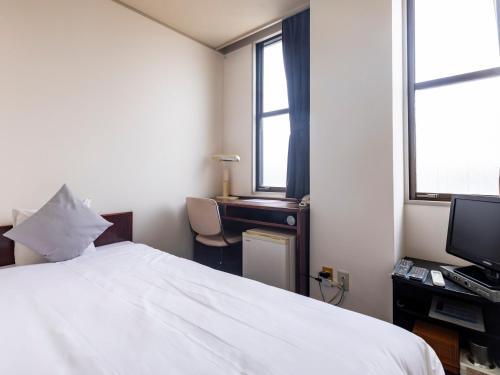 Postel nebo postele na pokoji v ubytování Tabist Business Hotel Suehiro Matsuyama
