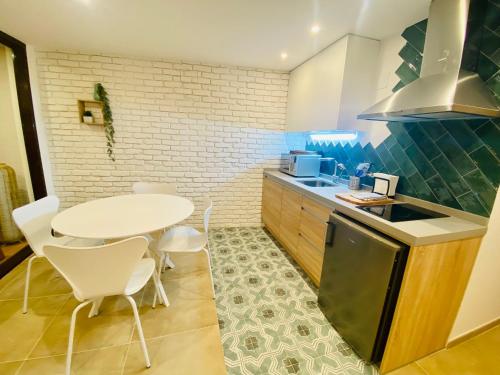 a kitchen with a table and a table and chairs at SUITE SORPRESA VuT LA TABERNA in Arenas de San Pedro