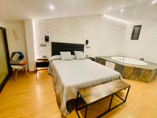 a bedroom with a bed and a bath tub at SUITE SORPRESA VuT LA TABERNA in Arenas de San Pedro