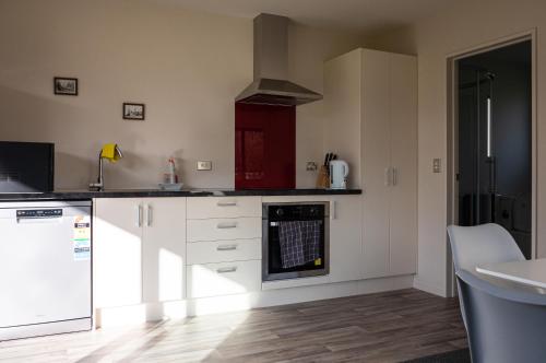 a kitchen with white cabinets and a stove top oven at Guest Suite in Peaceful Location Roxburgh in Dumbarton